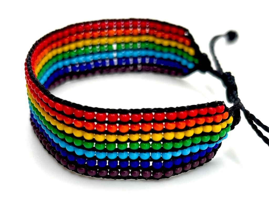 Handcrafted rainbow beaded bracelet featuring striped patterns in red, orange, yellow, green, turquoise, blue, and purple.